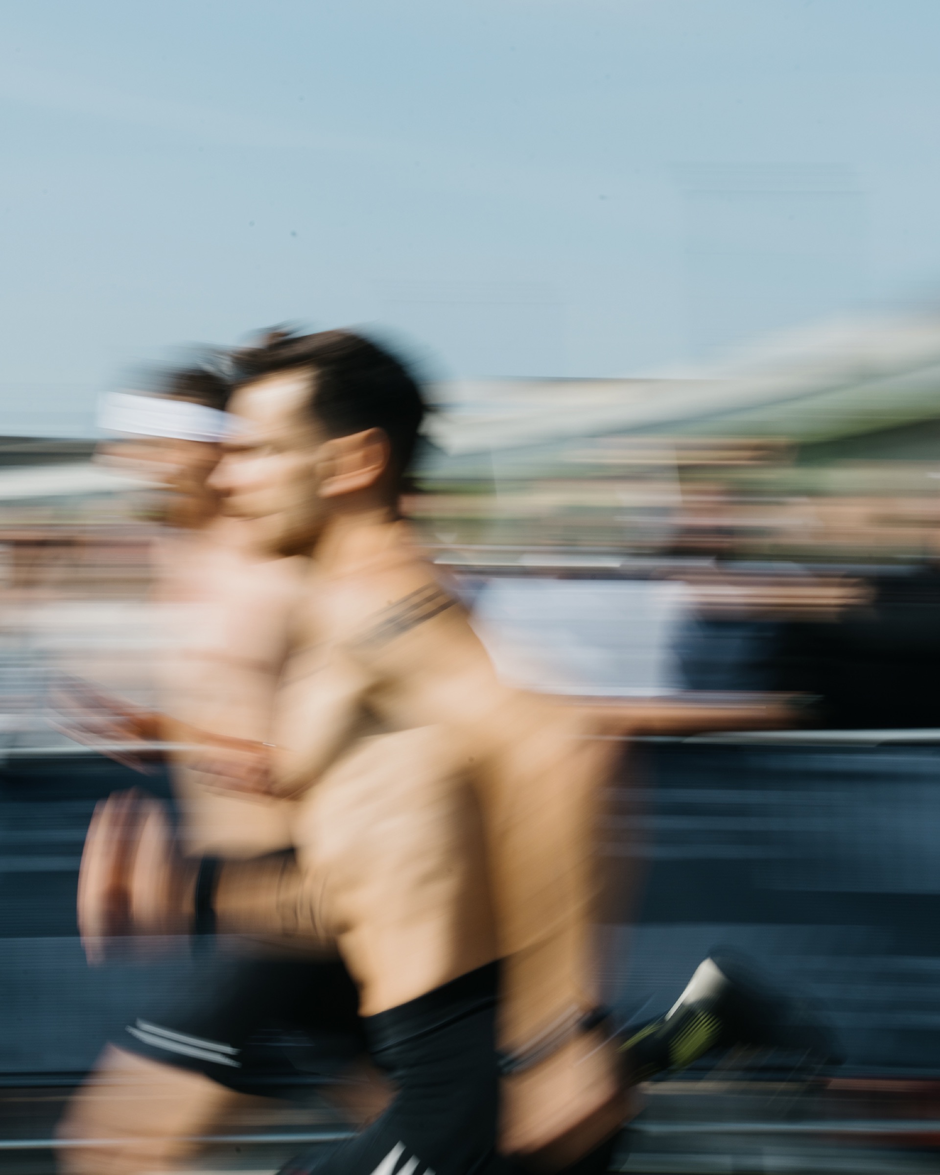 An athlete running past barbells, motion-blurred